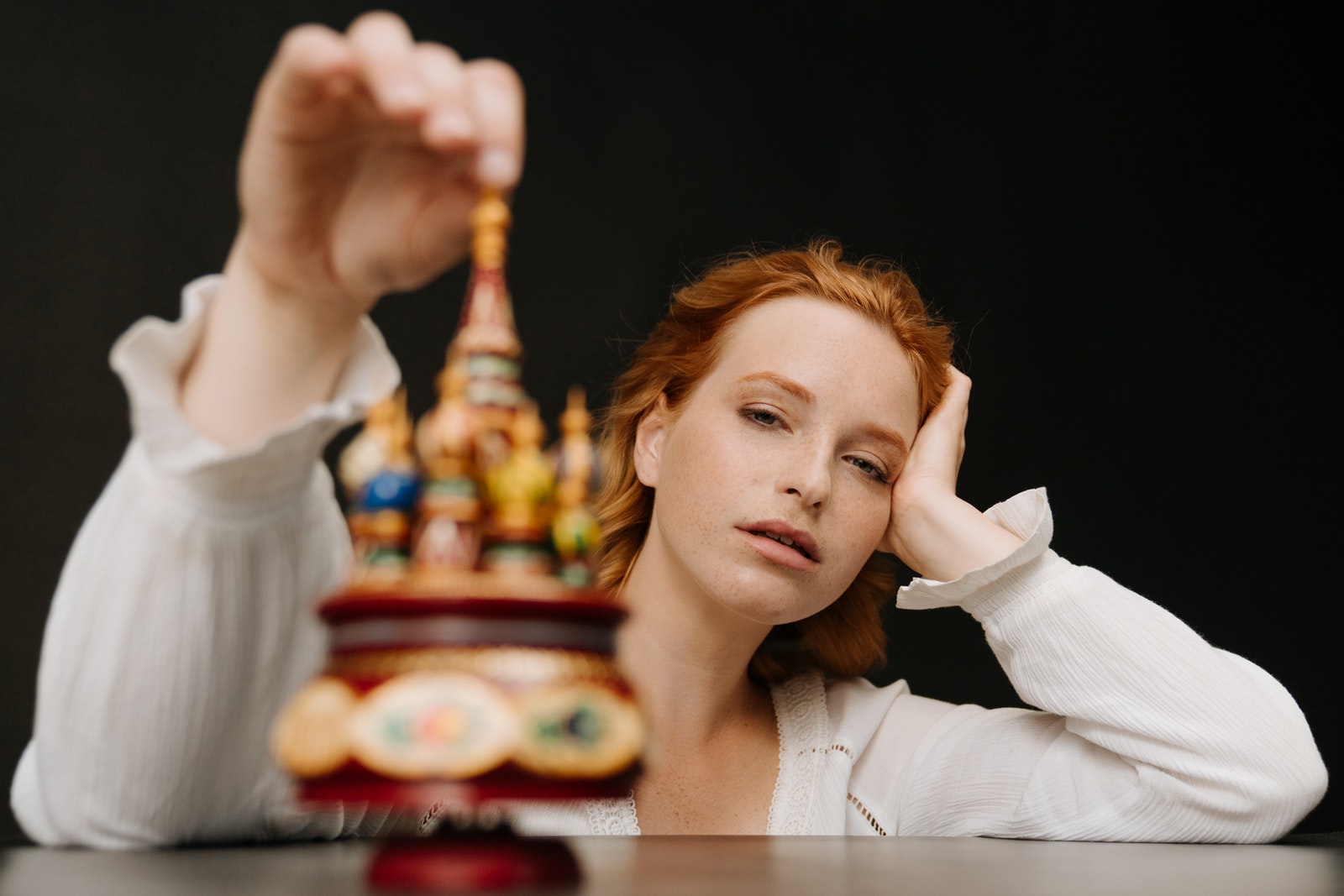 Woman in White Long Sleeve Shirt Holding Her Face