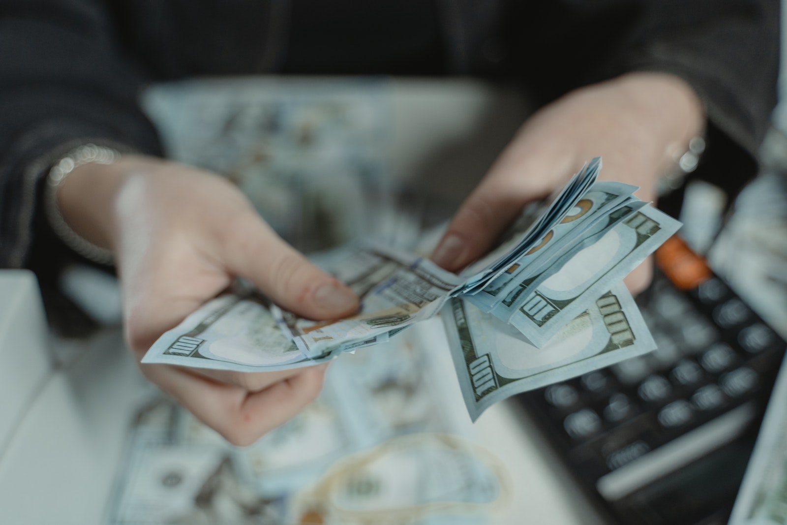 Person Holding Fan of 100 Us Dollar Bill