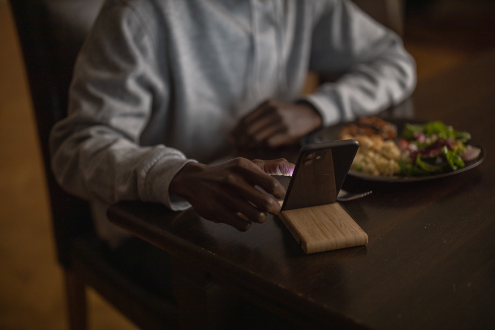 Person in Gray Long Sleeve Shirt Holding Black Smartphone