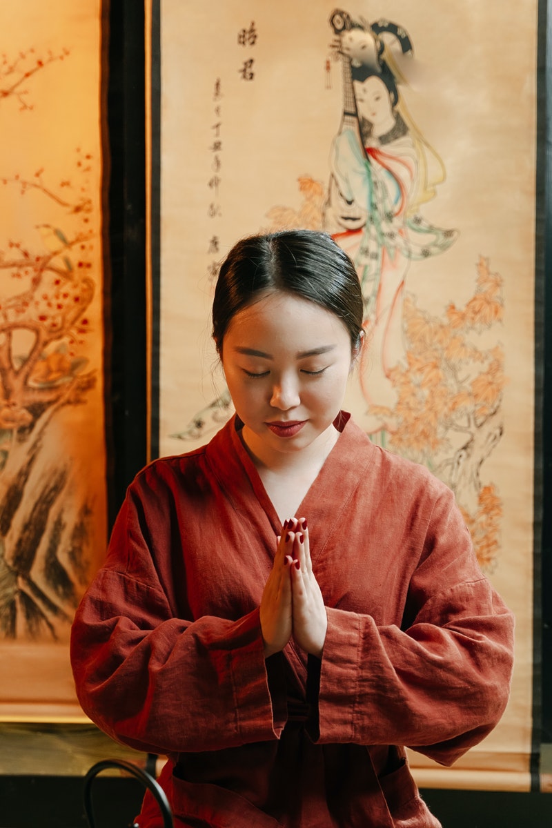 Woman in Red Robe Holding White and Red Textile