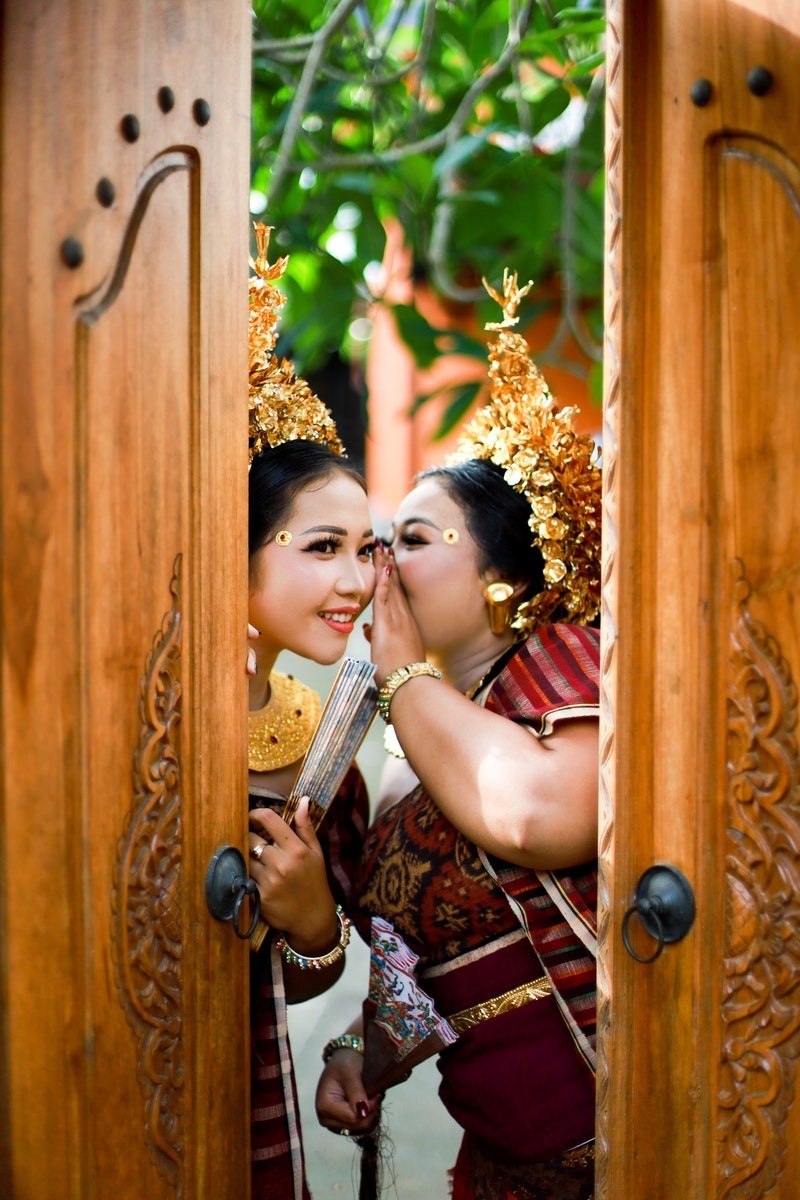 Woman in Red and Brown Dress Holding Brown Wooden Door