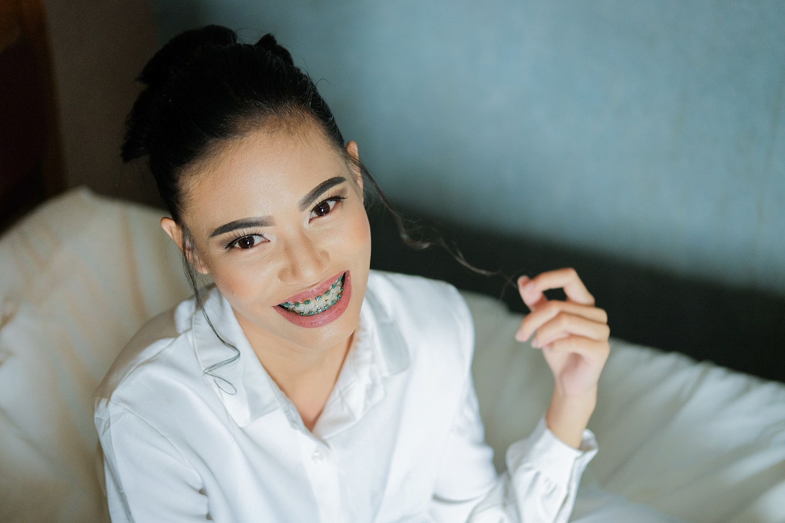 women's sitting on sofa wearing white dress shirt