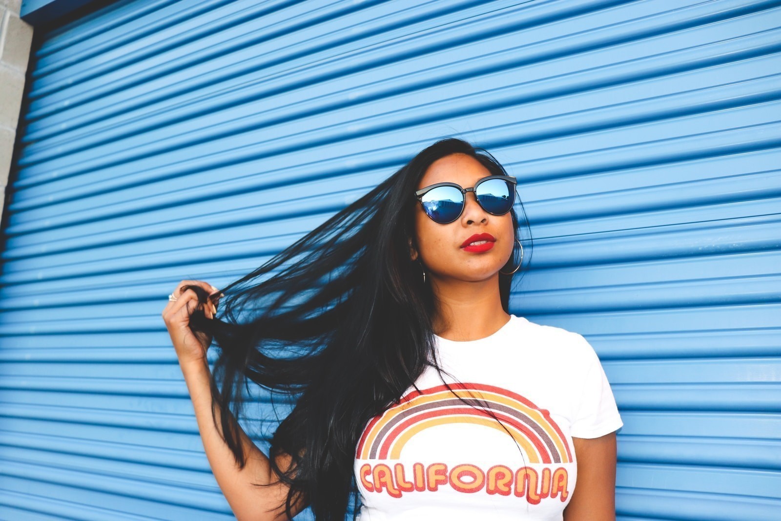 woman standing beside blue roller shutter