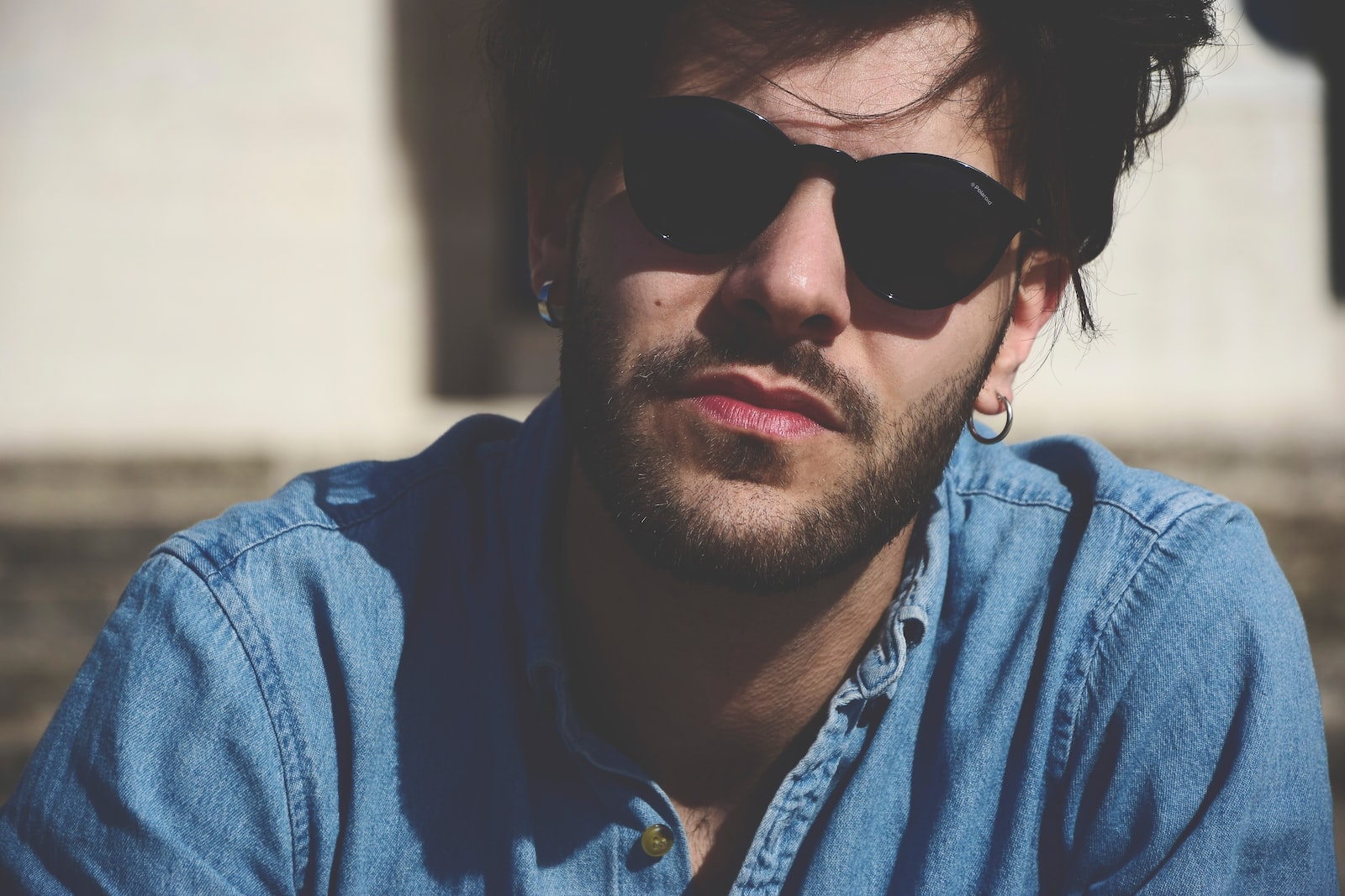 man wearing blue denim top and black sunglasses