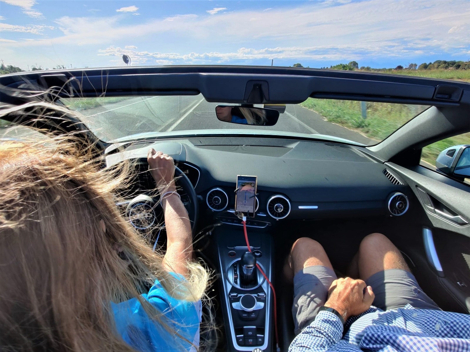 woman in white and blue long sleeve shirt driving car